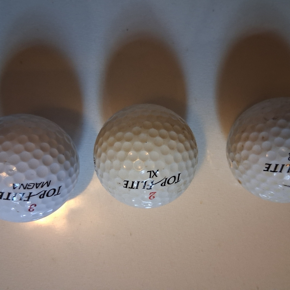 Three Vintage Top Flite golf balls